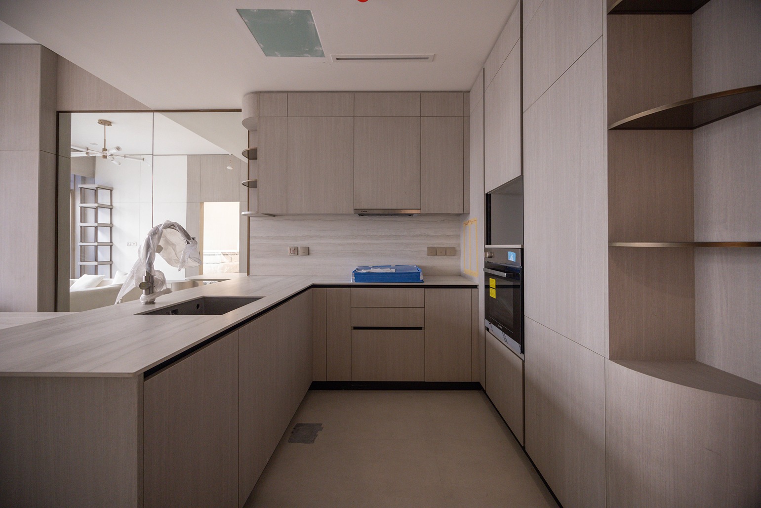Pearl House By Imtiaz A modern kitchen featuring light wood cabinetry, a sleek countertop, built-in appliances, and a minimalist design.